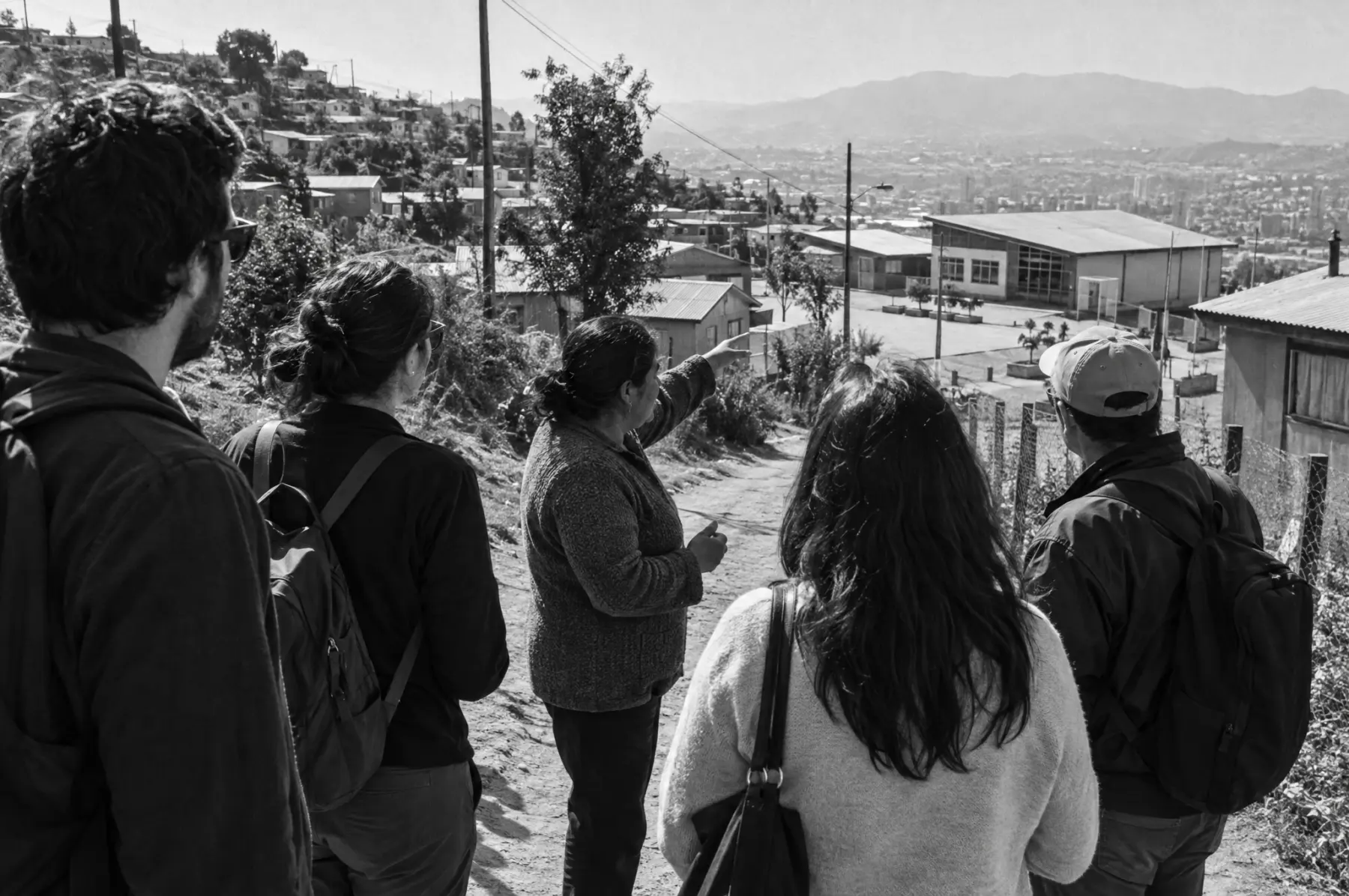 Un grupo de visitantes recorre una comunidad junto a una dirigenta local
